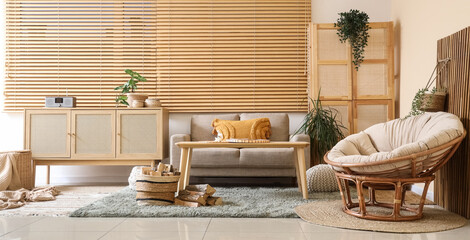 Obraz premium Interior of living room with sofa, armchair, coffee table, commode, closet and firewood near window