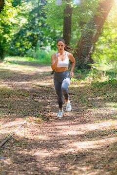 Jogging through forest path during fitness training session in natural environment.