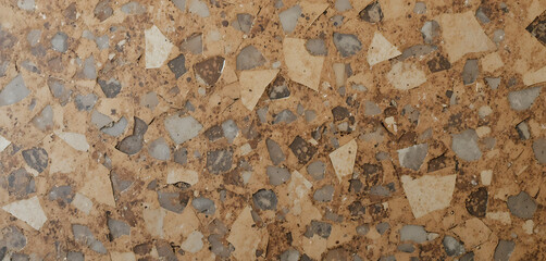 Fototapeta premium Terrazzo floor or surface with small stones and chips in brown, beige, and gray tones