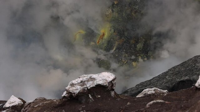 Inside Mount Bromo volcano crater with dense steam, sulfur deposits, and rugged volcanic terrain , East Java, Indonesia