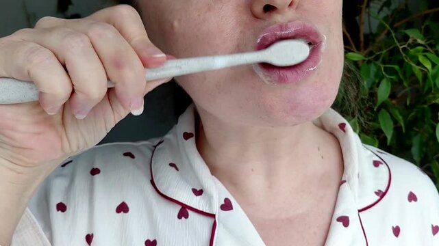 A woman brushes her teeth in close-up