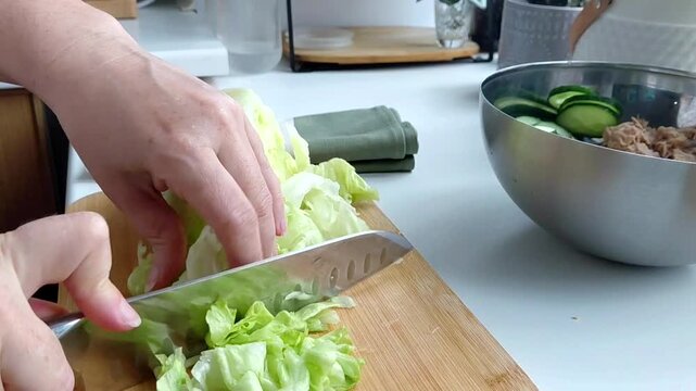 Slicing fresh iceberg lettuce with knife.