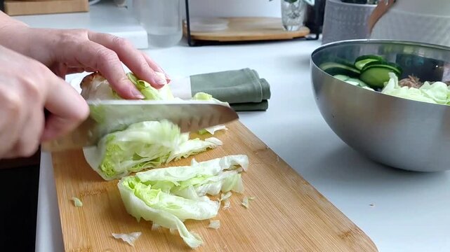 Slicing fresh iceberg lettuce with knife.