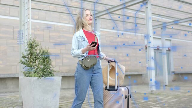 Woman traveler using phone, pulling bag at hub, blue squares appearing causing scanning to orient
