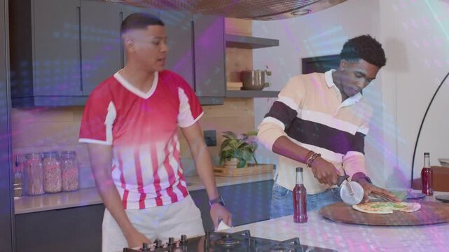 Two men leaning, cutting pies with cutter in kitchen, adding green topping to serve, lights overlay