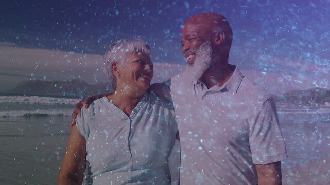Senior couple holding hands walking along shore, sharing joy, sparkling overlay drifting for travel