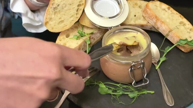 Gourmet Spreading Pate spread on bread with microgreens and baguette closeup appetizer serving Spreading Pate On a piece of Bread. High quality 4k footage
