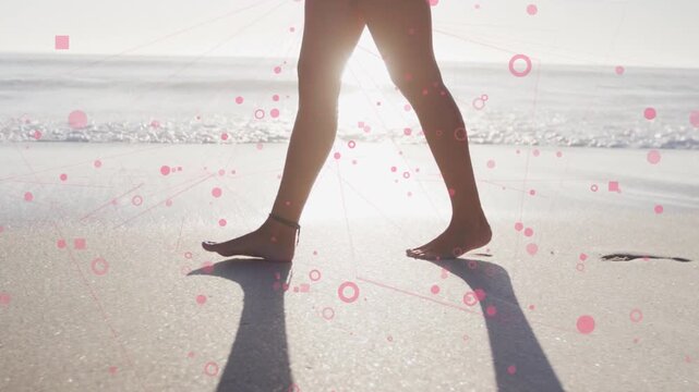 Woman beginning walk shoreline for wellness walk, leaving prints as pink graphics float around legs