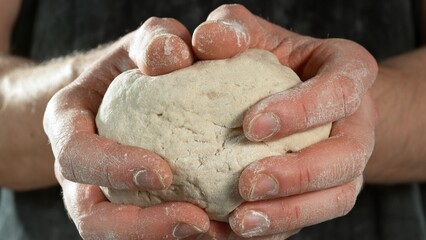 Fototapeta premium The cook kneads the dough in his hands
