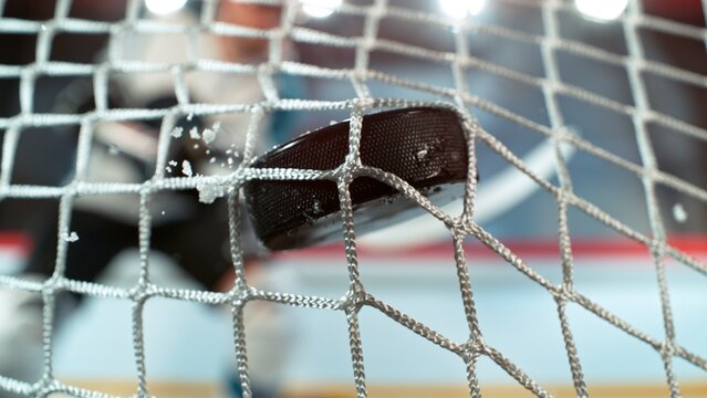 An ice hockey puck hitting the back of the net