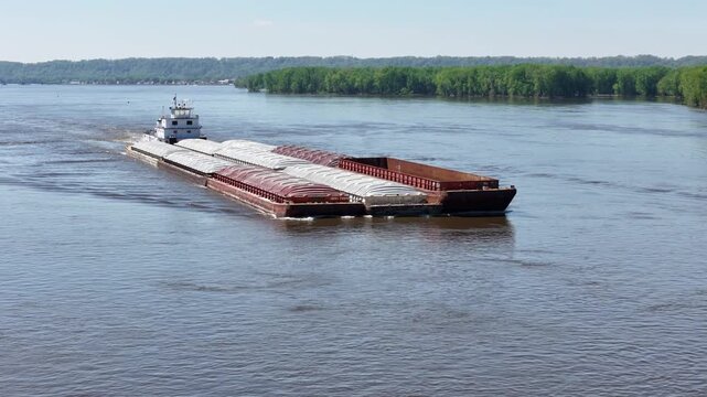 Tug boat pushing a large set of barges North up  the Mississippi River