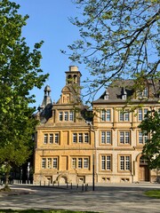 Fototapeta premium Beautiful historic building with ornate facade and tower under blue sky