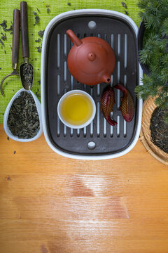 Tea ceremony setup with Yixing teapot, tea cup, and fish figurines on chaban tray, top view. Traditional herbal practice for meditation and wellness. Zen lifestyle concept and organic drink