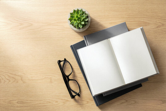 Open blank notebook on stack of hardcover notebooks with eyeglasses and succulent on wooden desk, top view