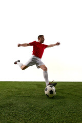 Obraz premium Soccer player stepping on ball in red jersey on grass with wide copy space. Concept of football control, sports training, athlete promo, tournament poster and motivational campaign.