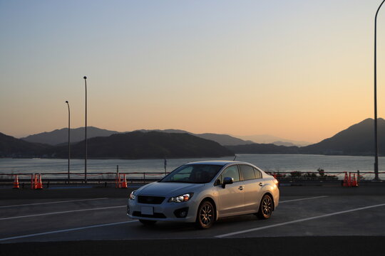 車と夕焼けの海の風景