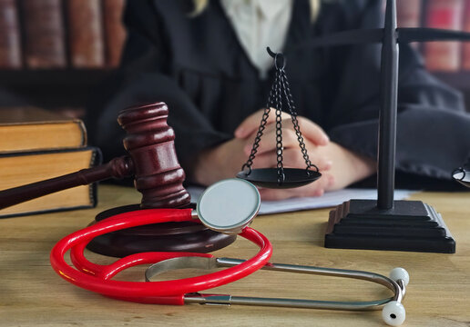 Judge and medical tools on a desk with legal books in the background