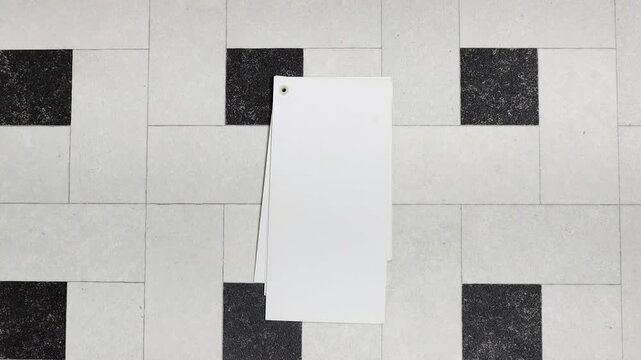 A set of blank white cards arranged in a fan on a pale tiled floor creates a clean, minimalist backdrop ideal for design, stationery layouts, invitations, or calligraphy concepts