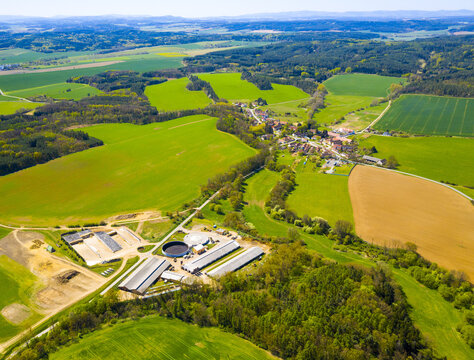 Biogas plant and farm in fields. Renewable energy from biomass. Aerial view to Czech industry. Sustainable development in European Union.	
