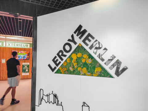 Le Mans, France - April 24, 2026: Leroy Merlin store entrance sign featuring green plants and logo with a customer walking in background