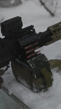 Soldier hands operating PKM machine gun on snowy firing range