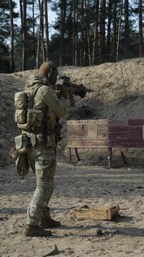 Soldier in full tactical gear performing mission in urban ruins back view