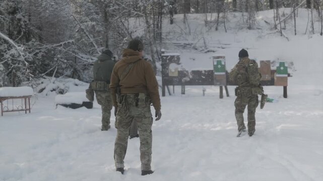 Military instructor supervising tactical drills on winter range