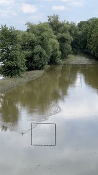 Wide brown river overflowing banks after heavy rain natural flood disaster scene in Europe