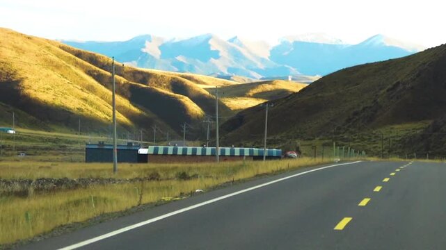 Upland, rolling country. The road through the green hilly grassy area of the Xinjiang Uygur Autonomous Region. China