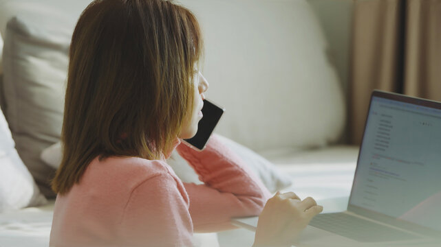 Side view woman having phone conversation while working online from comfortable home office environment