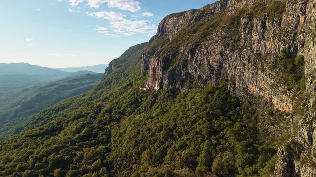 Aerial view famous Ostrog Monastery and the surrounding vertical cliffs in Montenegro at sunset. Vertical drone shot