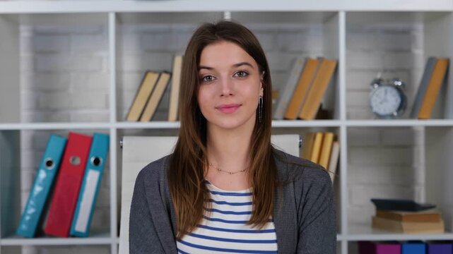 Pretty young woman posing to webcam and making video at home, online, videocall meeting. Lady is shy in front of the camera. Webcamera view. Real time concept.