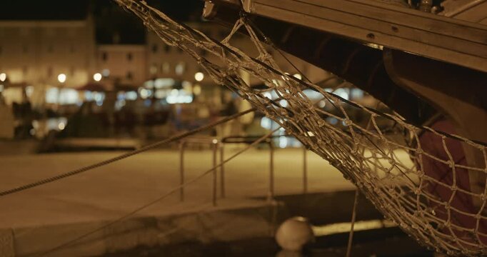 Wooden boat bow with rope netting at night