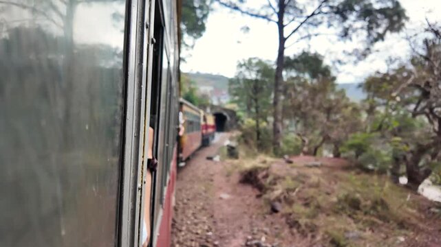 A person looking out of a train window at the engine.