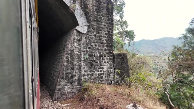 A scenic view from a train window on a hillside journey.