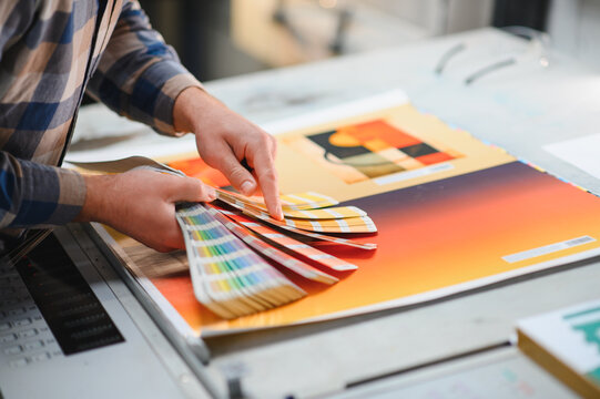 Print worker checking color swatches at factory press
