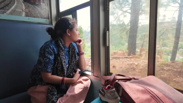 A thoughtful woman looks out a train window during her journey.