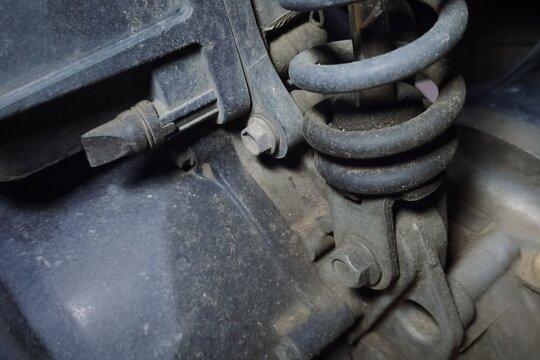 Oil leakage on motorcycle rear shock absorber with spring suspension detail.