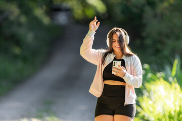 Obraz premium Young woman enjoying music outdoors moving to rhythmic sounds