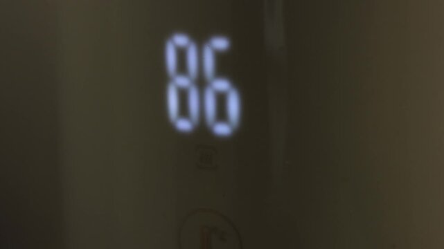 Digital thermometer displaying increasing temperature readings of 86, 92, and 99 degrees Fahrenheit in a close-up view, showcasing temperature progression