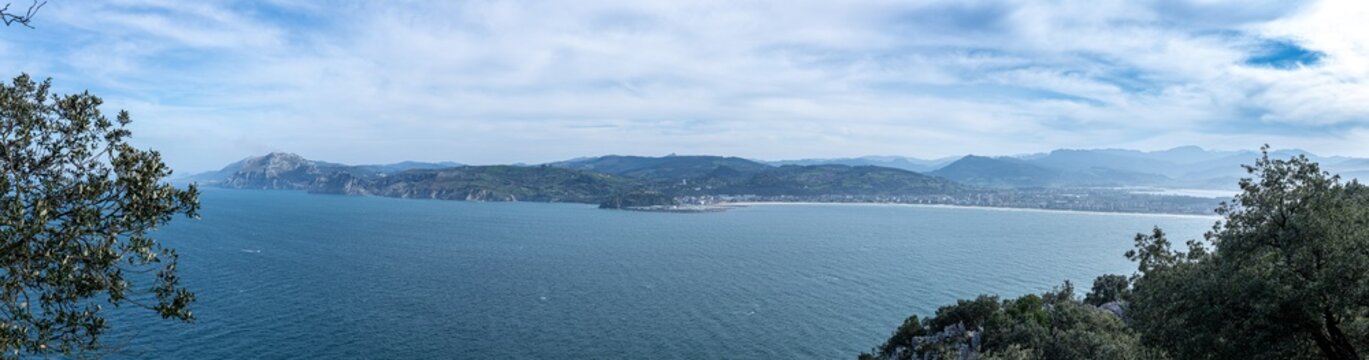 Panoramic view showing the bay, coastline, town, and mountains under a blue sky laredo cantabria spain