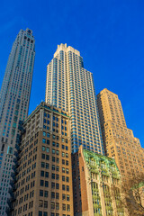 Fototapeta premium Skyscrapers touching the sky in vibrant Lower Manhattan during midday