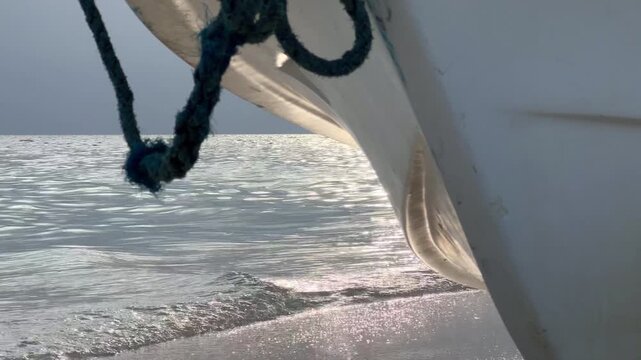 Close-up of boat detail with rope and water reflection in sunlight
