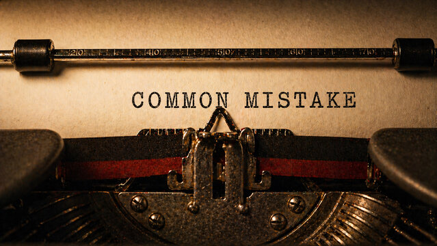 Close-up of vintage typewriter with "COMMON MISTAKE" text typed on paper in warm atmospheric lighting