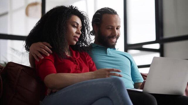 Black woman and her boyfriend booking hotel tickets on a laptop, online shopping