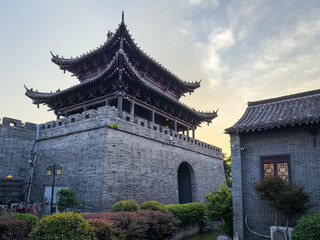 Naklejka premium Towering Ancient Architecture Under the Soft Glow of Sunset in Tranquil Surroundings