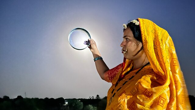 An Indian woman looking at the moon through a sieve during the Karwa Chauth festival.