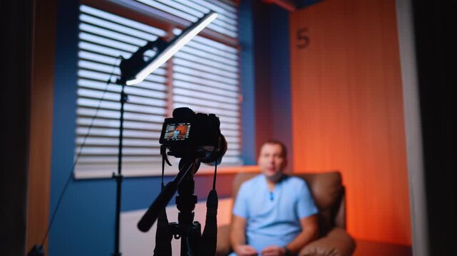 Soffit and camera are directed on the man wearing blue uniform. Male doctor records a medical blog.