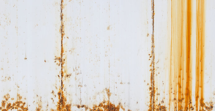 A high-resolution texture of a white painted full frame metal surface with heavy orange rust streaks and weathered grunge details, perfect for industrial backgrounds. Background Pattern.