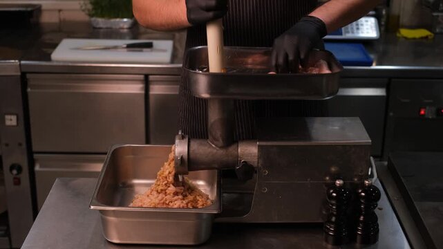 Male chef in professional restaurant kitchen making minced chicken fillet

